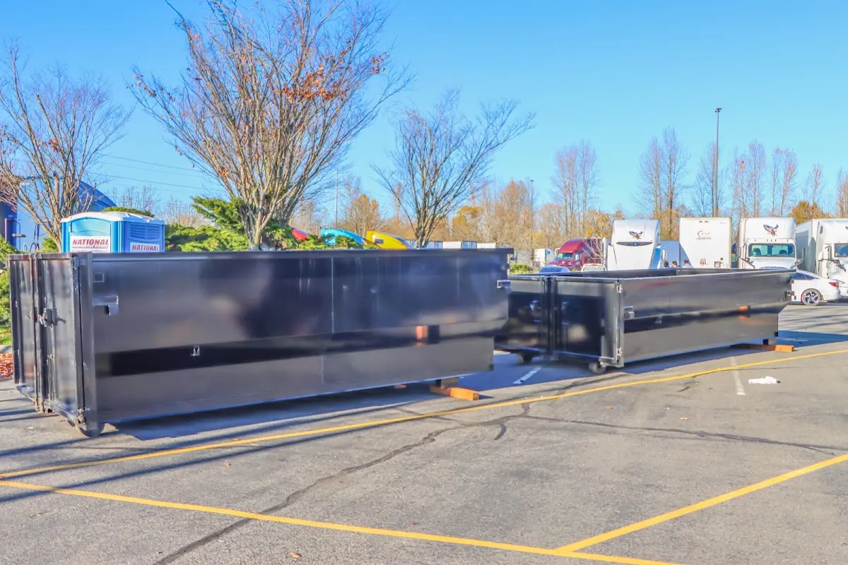 Professional dumpster rental service with roll-off container on residential driveway in Prichard